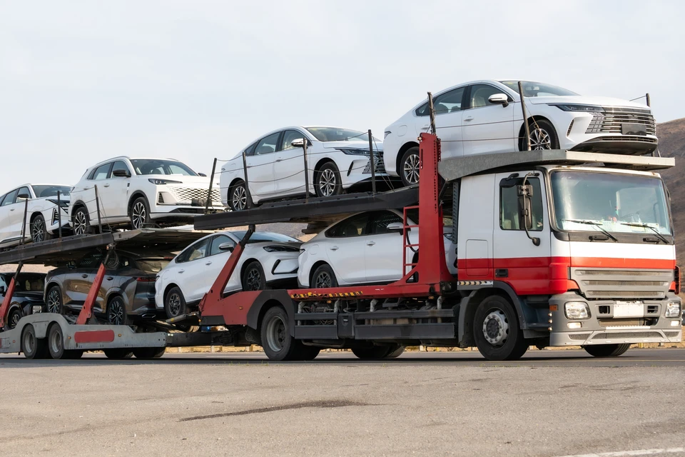 Technicien automobile en vêtements de travail professionnel contrôlant minutieusement un véhicule neuf dans l'atelier GH Auto. Il inspecte le capot ouvert avec une lampe de diagnostic, examinant le moteur et les éléments mécaniques. Vue en plongée légère montrant le professionnel concentré sur son inspection, accompagné de son équipement de diagnostic, avec un atelier automobile équipé flou en arrière-plan. Éclairage professionnel naturel, aspect authentique et sérieux.